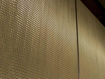 Bronze architectural rigid mesh is covering the interior elevator.
