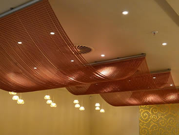 Copper color aluminum chain curtain is installed on the ceiling with a wave structure.