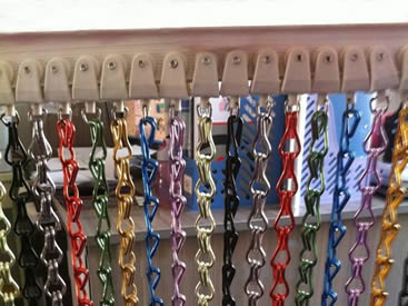 Several different colors of aluminum chain curtains are installed on the flexible track.