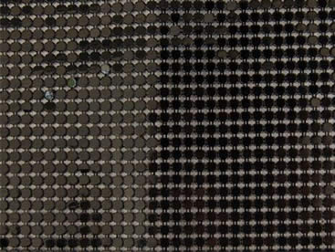 A piece of black metallic fabric cloth on the ground.