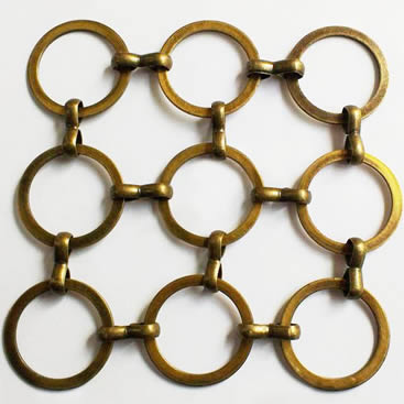A piece of brass S hook metal ring mesh with flat wire on the gray background.