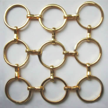 A piece of brass S hook metal ring mesh with round wire on the gray background.